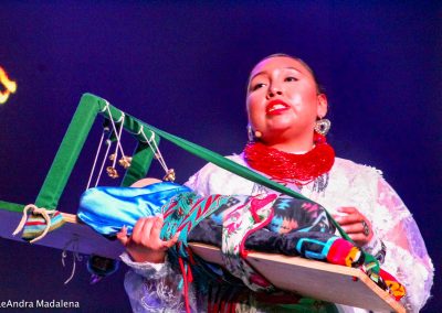 Miss Indian World contestant swaddling a baby