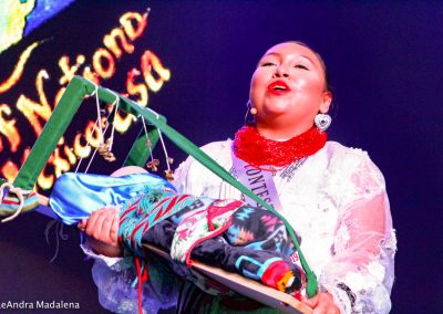 Miss Indian World contestant swaddling a baby