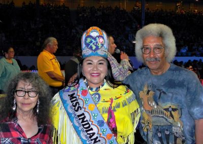 Miss Indian World smiling with two people